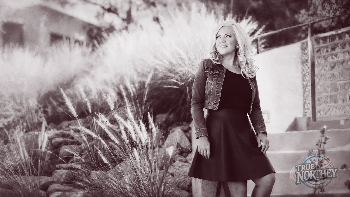 Jessica Northey standing in a sunlit desert garden, looking thoughtfully into the distance for the Kindness Ain’t Blindness blog post